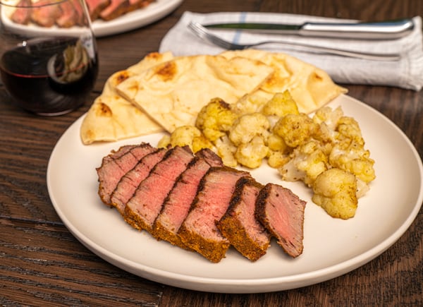 Turmeric and garlic grilled tenderloin with Indian-spiced grilled cauliflower and naan bread